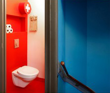 Bloedoranje toilet en knalblauwe gang